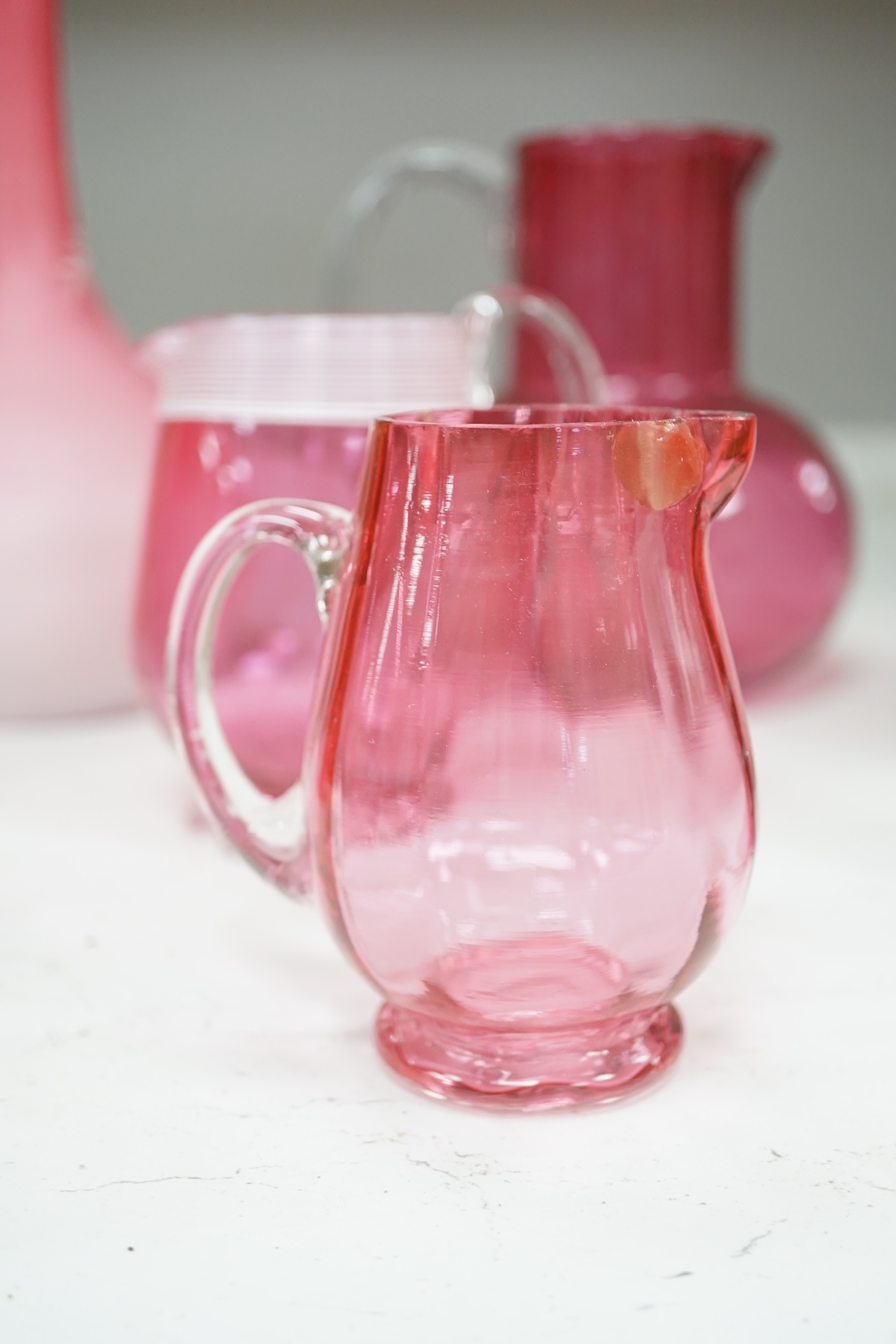 A pair of Victorian pink satin long necked vases, 25cm high, and five pieces of cranberry coloured glassware, (8). Condition - fair to good.